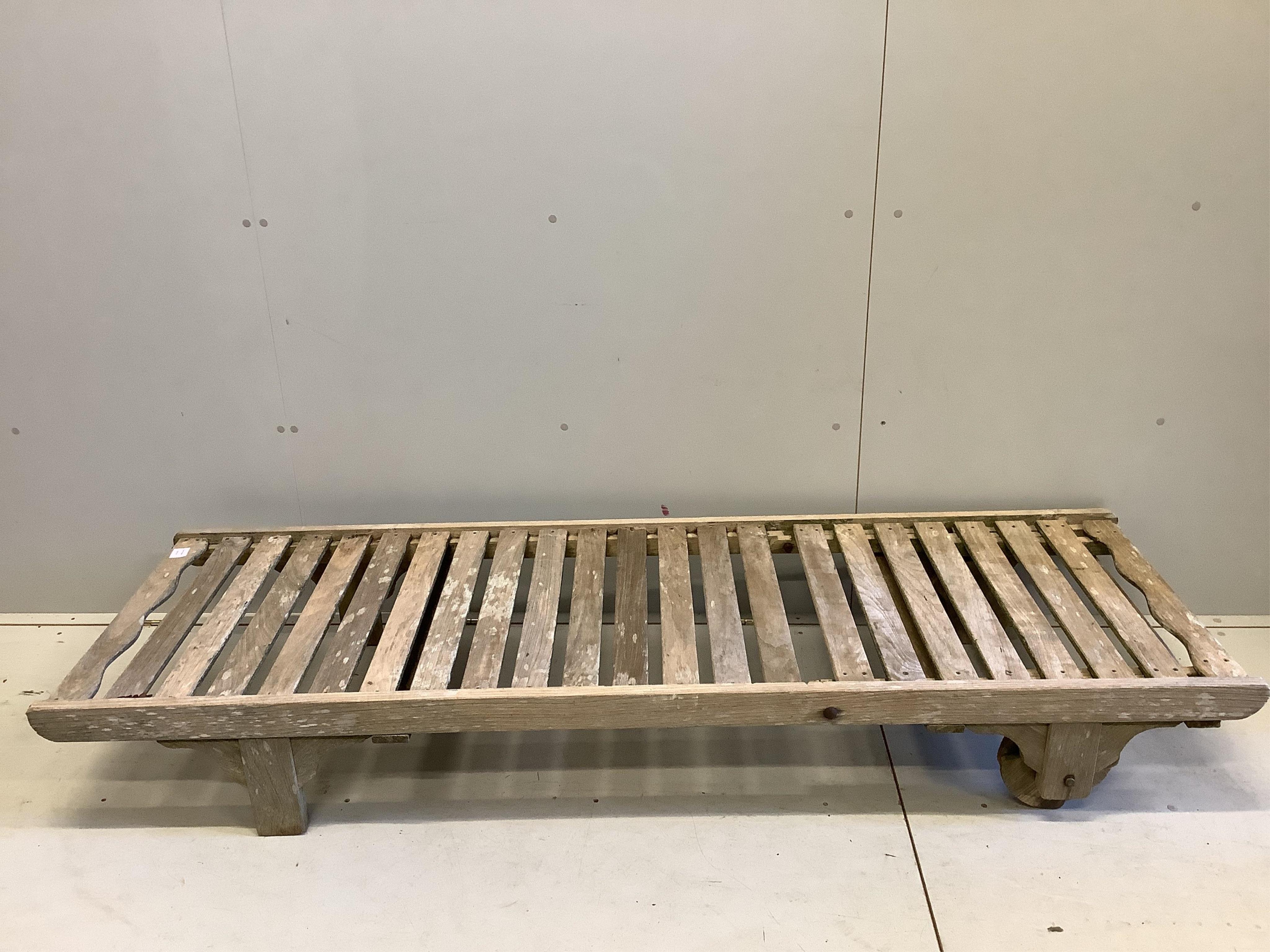 A weathered teak lounger, possibly Lister, width 64cm, length 195cm. Condition - poor